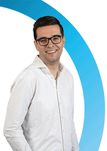 Een man met een bril en een wit shirt staat te glimlachen voor een witte achtergrond met een blauwe gebogen afbeelding.